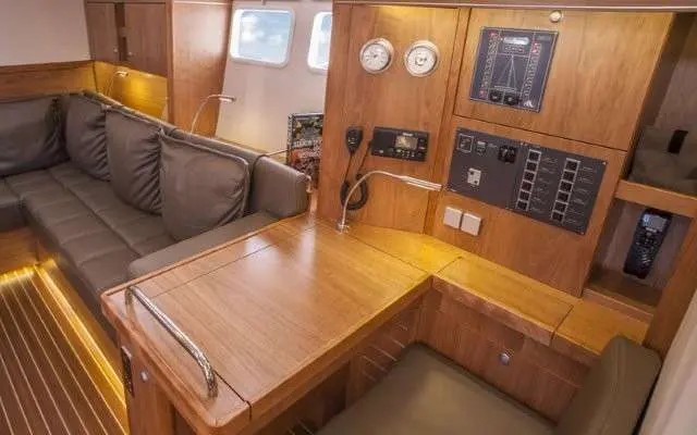 Hanse 505 — Vue intérieure du salon avec table, banquette et tableau de commande.