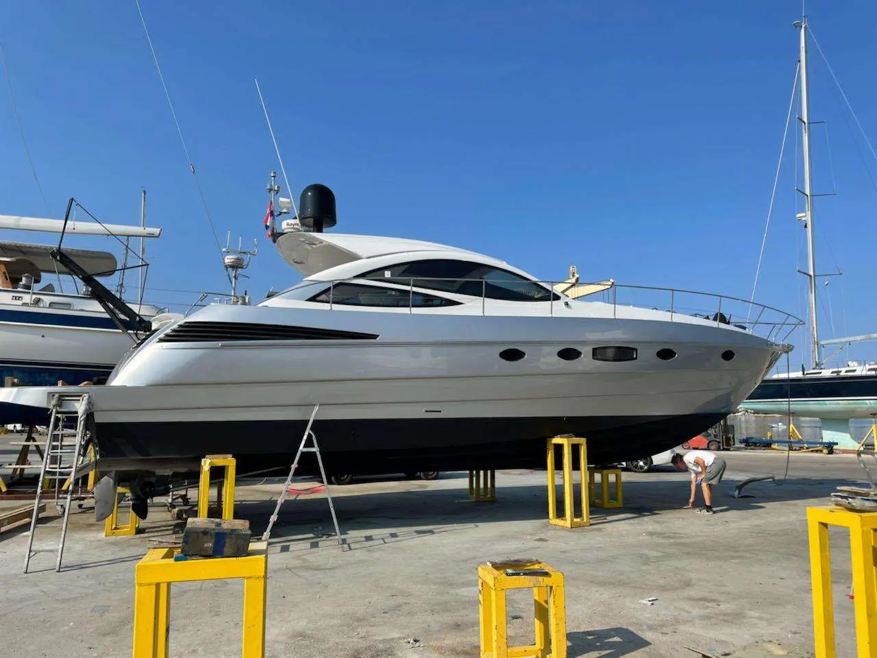 Pershing 46 — Bateau à moteur blanc présenté à sec dans un chantier nautique.