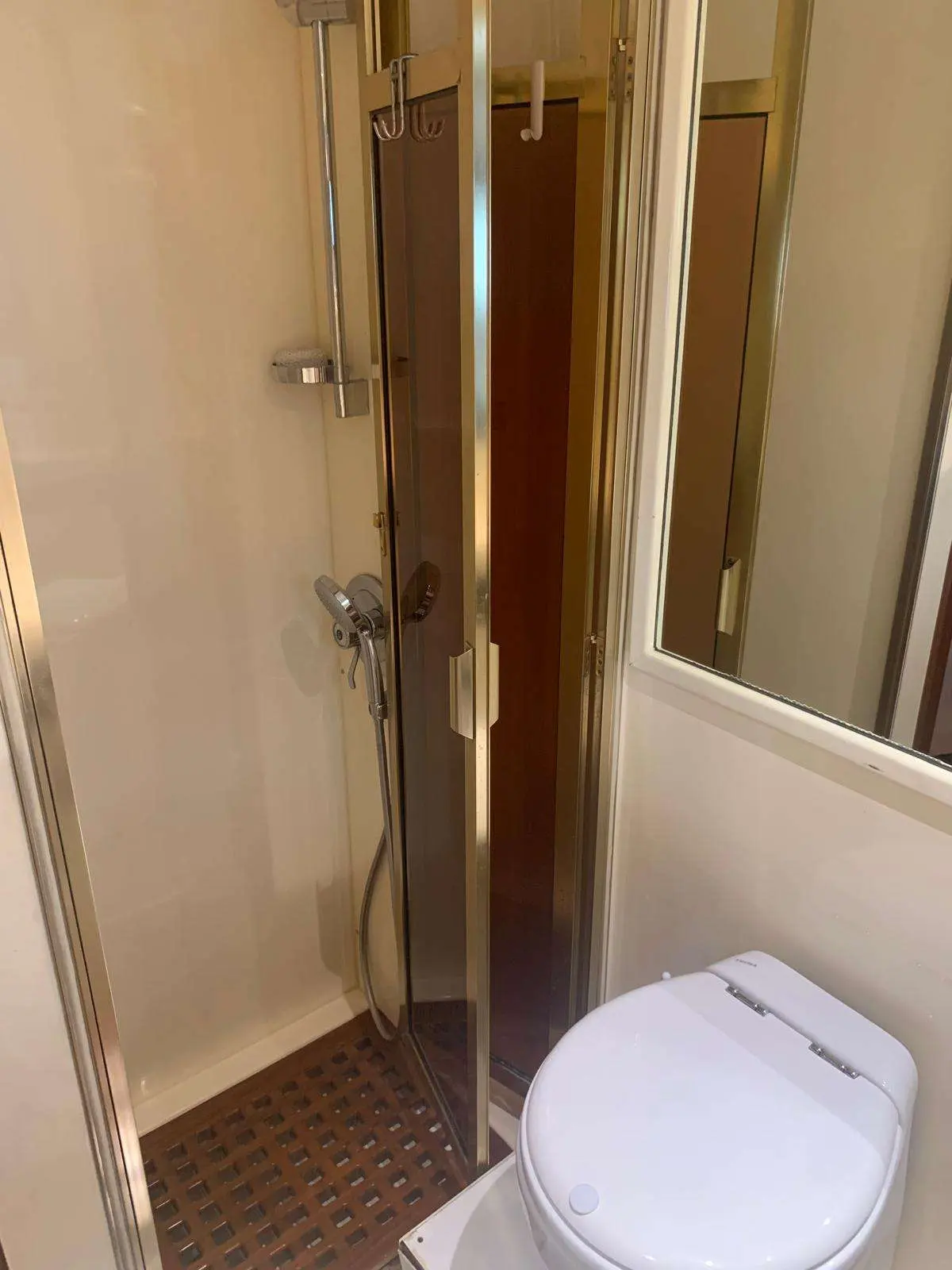 Johnson 56 — Salle de bain avec cabine de douche vitrée et toilettes à bord.