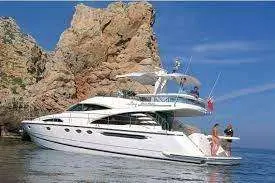 Fairline Squadron 58 — Bateau à moteur blanc photographié au mouillage près d’une côte rocheuse.