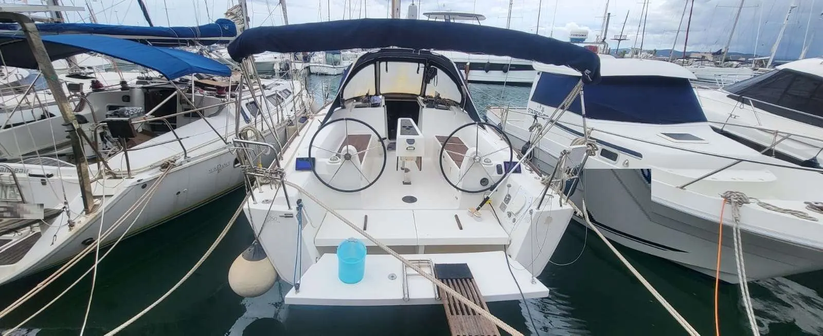 Dufour 350 — Vue arrière du cockpit d’un voilier amarré dans une marina.