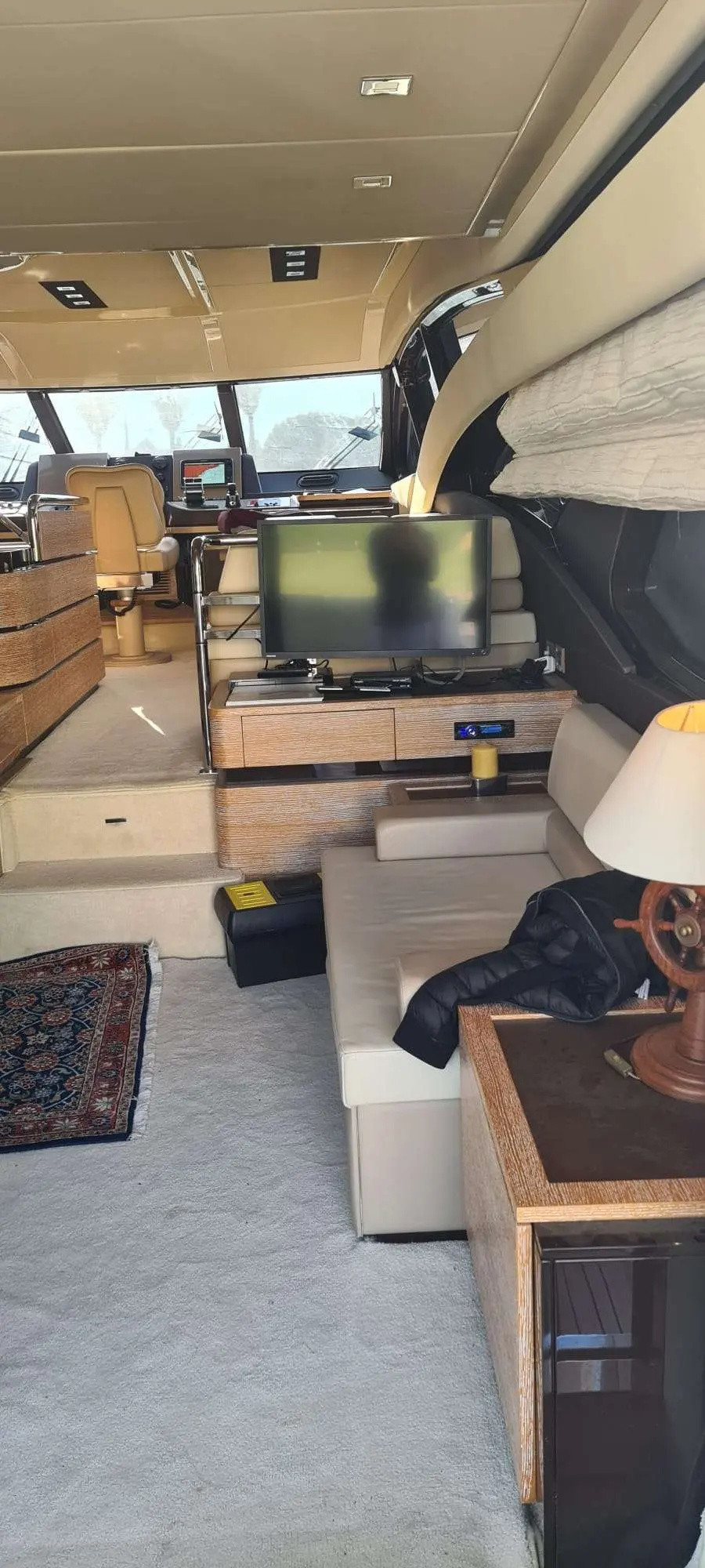 Azimut 60 Fly — Salon intérieur avec écran, poste de pilotage et banquette visibles.