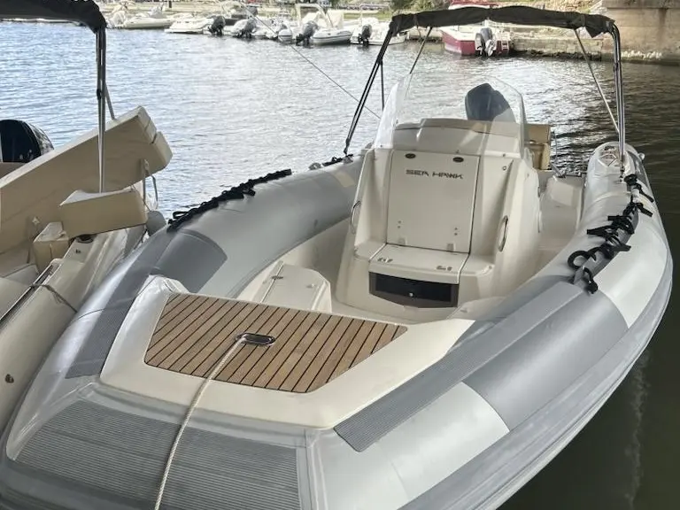 Kelt Sea Hawk 265 — Vue arrière d’un semi-rigide amarré, avec console centrale et plage avant en teck.