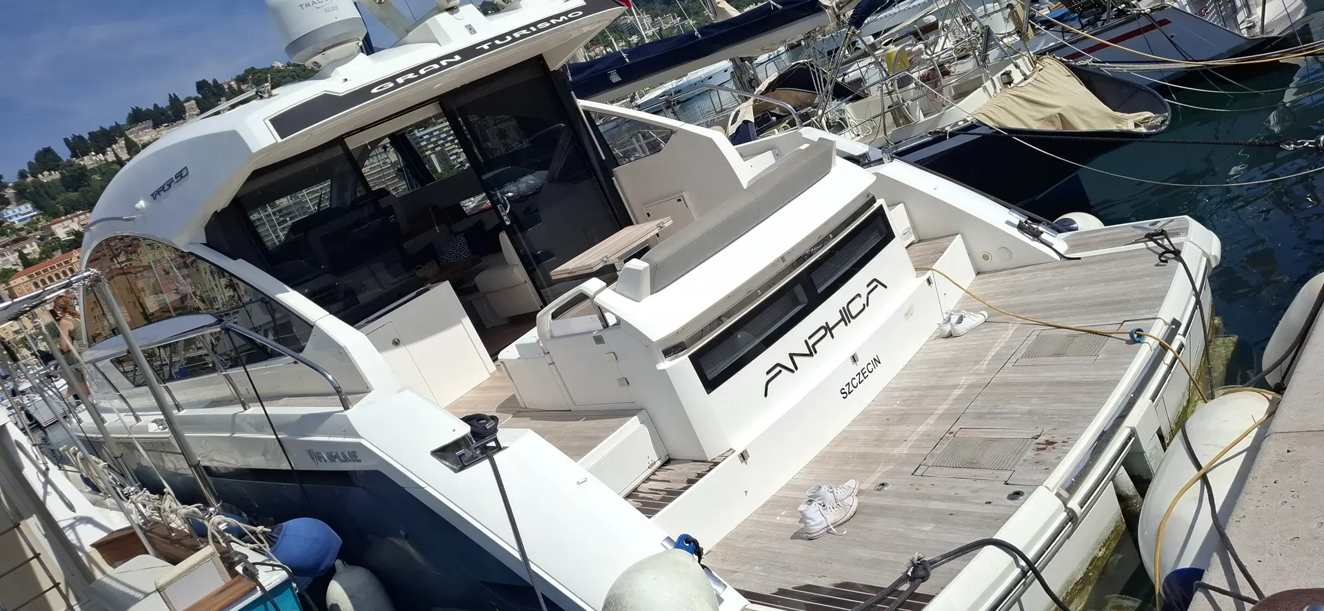 Fairline Targa 50 Gran Turismo — Vue arrière trois quarts d’un bateau à moteur amarré dans un port.