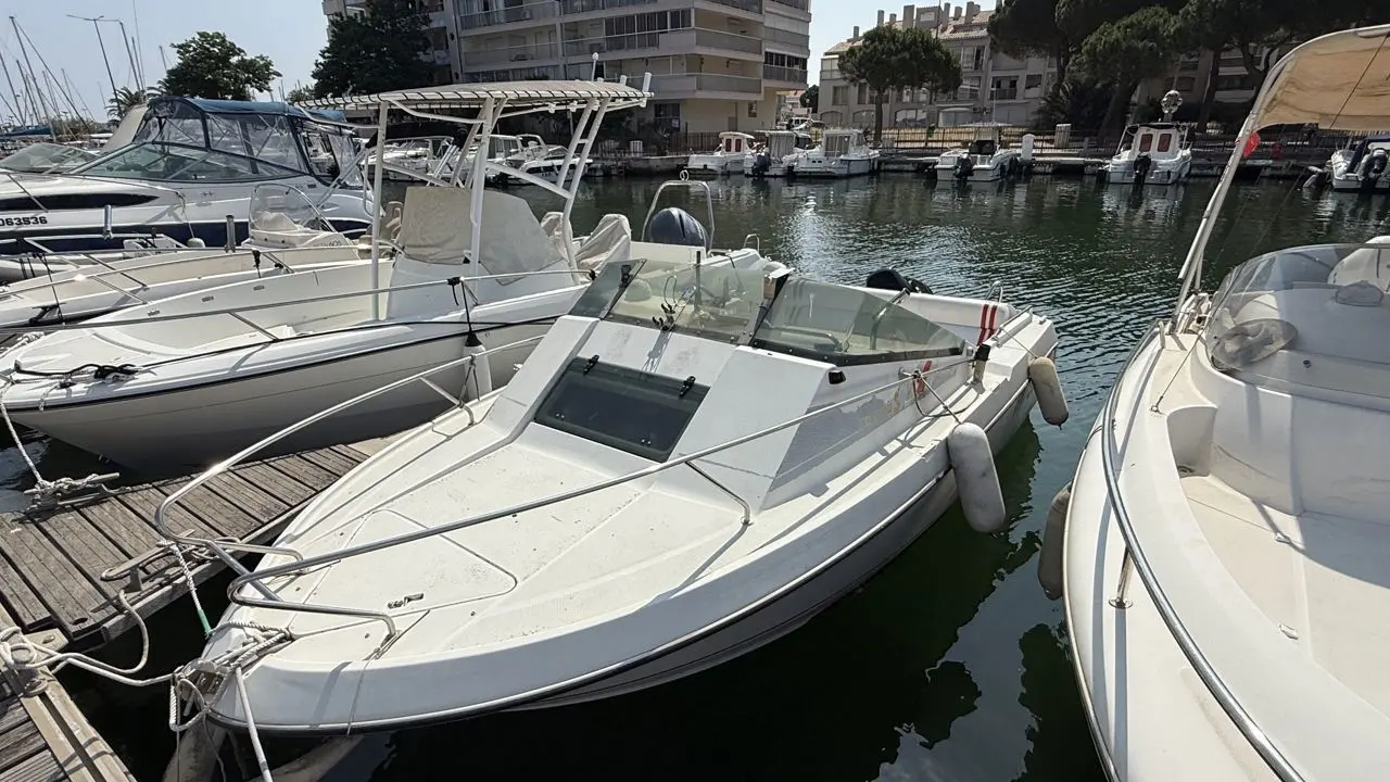 Beneteau Flyer 560 — Vedette blanche amarrée dans un port, photographiée de trois quarts avant.