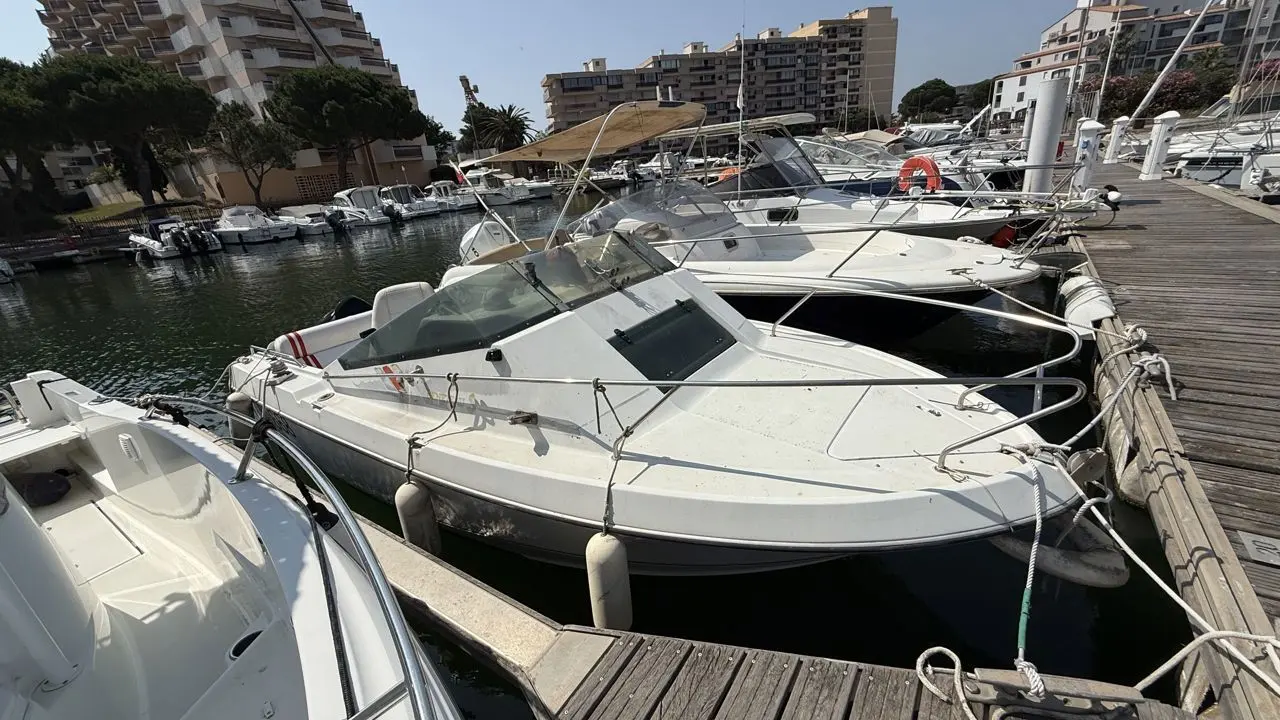 Beneteau Flyer 560 — Bateau à moteur amarré dans une marina, vu de trois quarts avant.