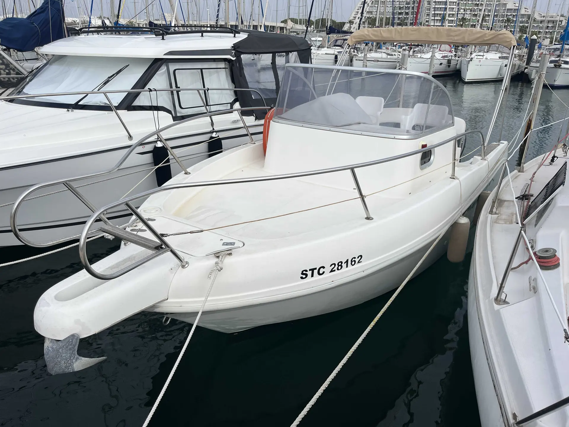 Capelli Cap 23 Open — Bateau à moteur blanc amarré, vu de trois quarts avant dans une marina.