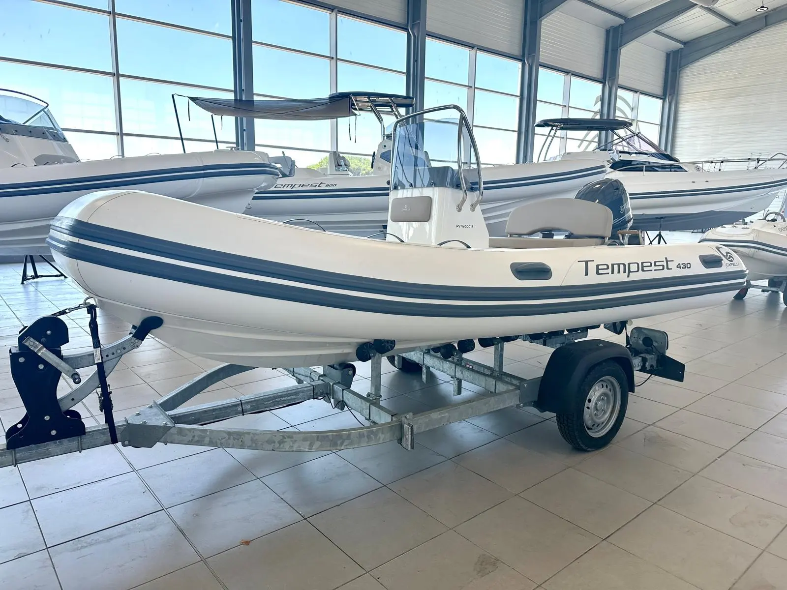 Capelli Tempest 430 — Bateau semi-rigide blanc exposé sur remorque dans un hall vitré.
