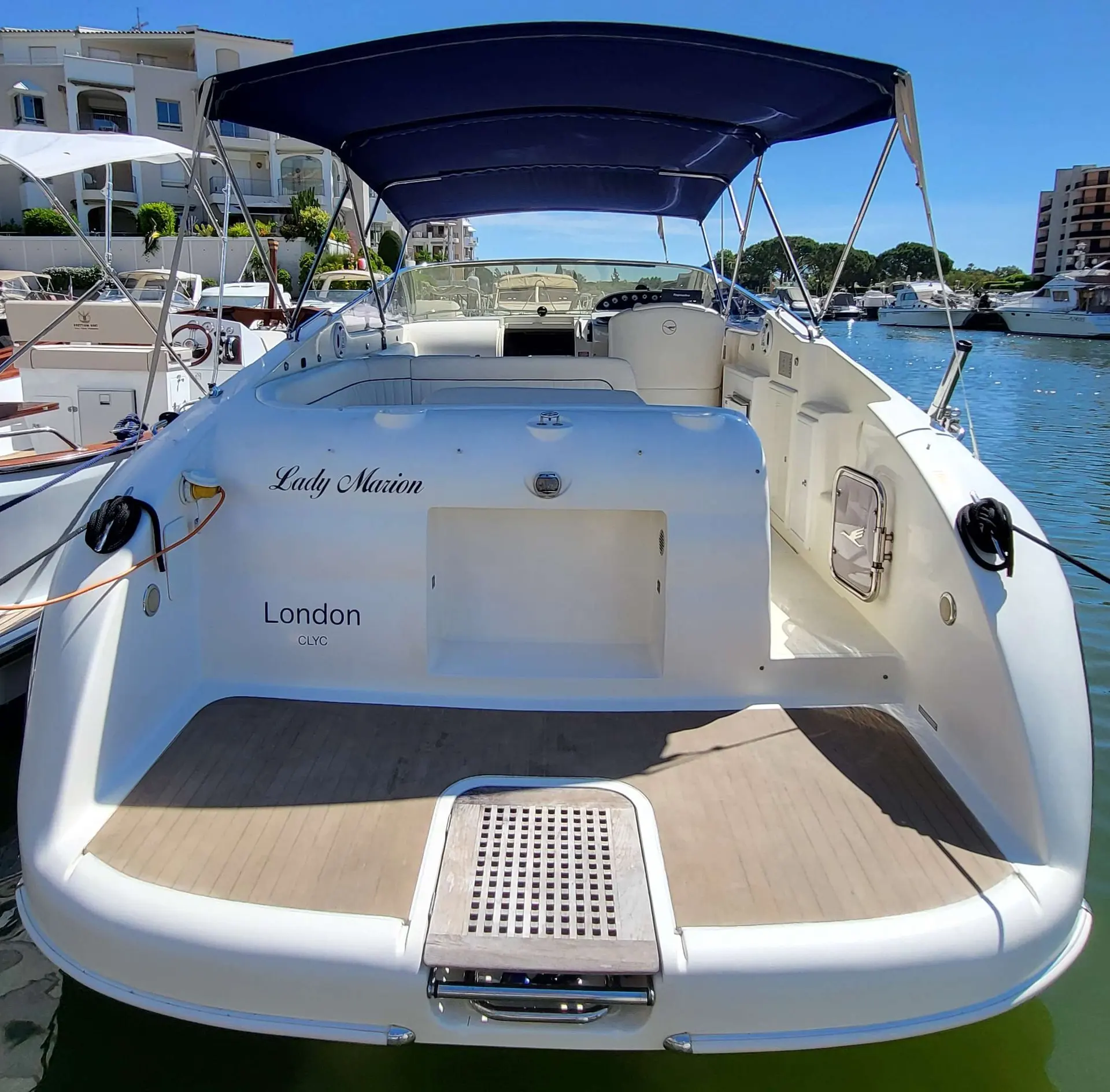 Airon Marine 300 — Vue du cockpit arrière d’un bateau amarré, avec taud et banquette arrière.