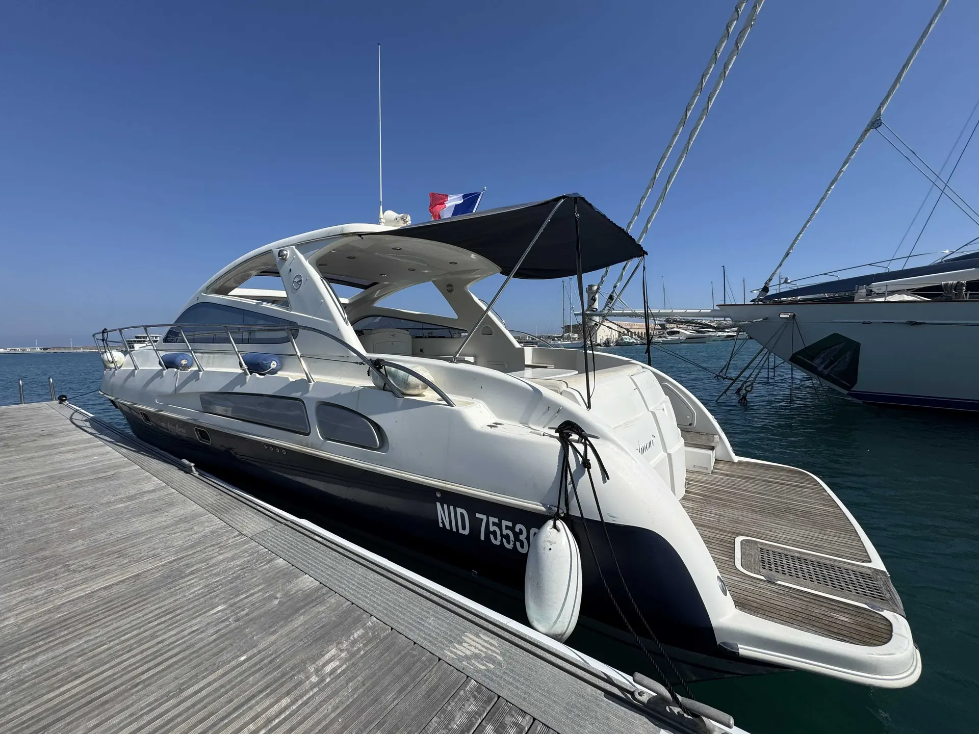 Airon Marine 43 — Bateau à moteur blanc amarré à un ponton, vu de trois quarts arrière.