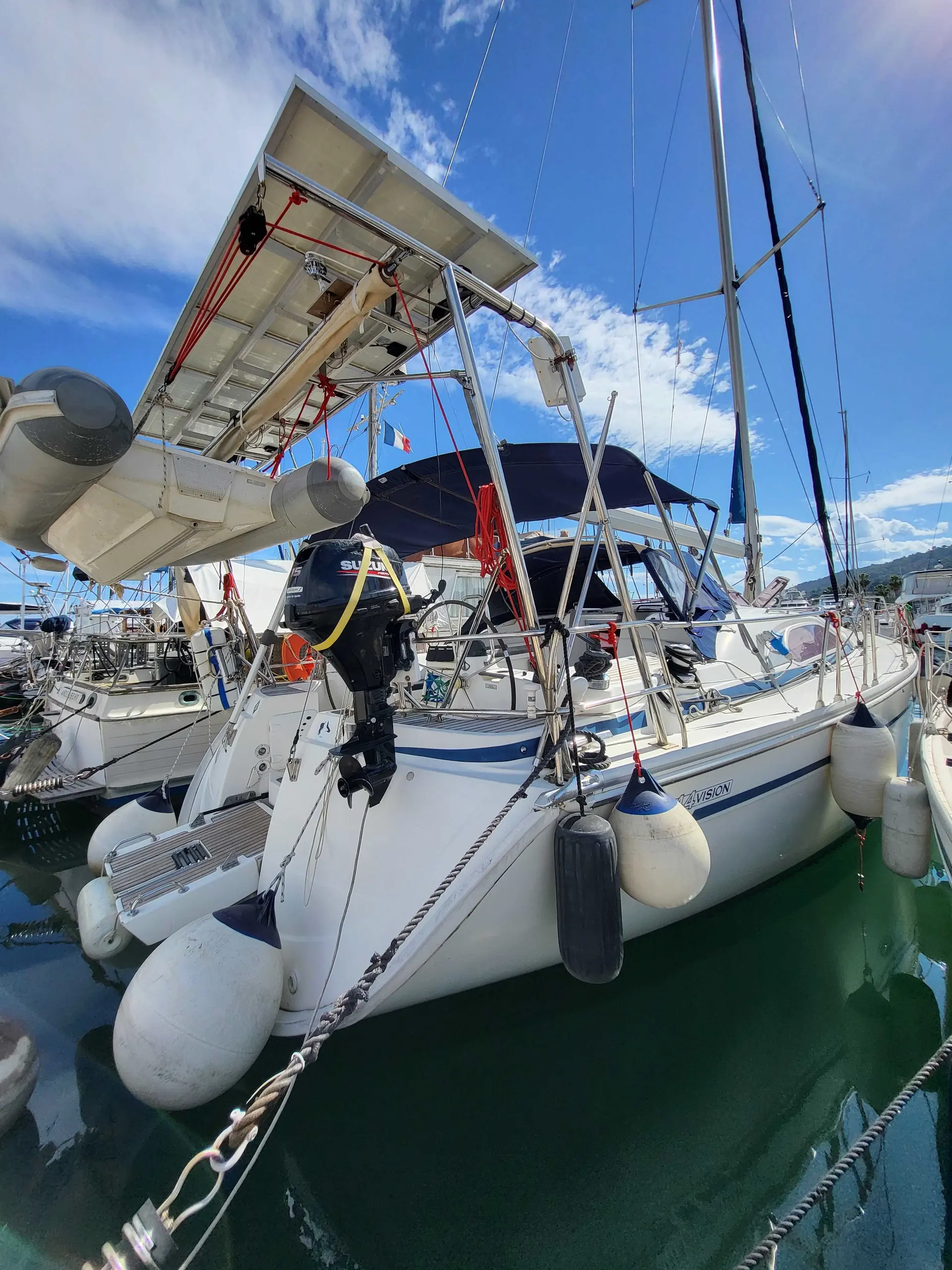 Bavaria Vision 44 — Vue arrière d’un voilier amarré, avec annexe, moteur hors-bord et gréement.