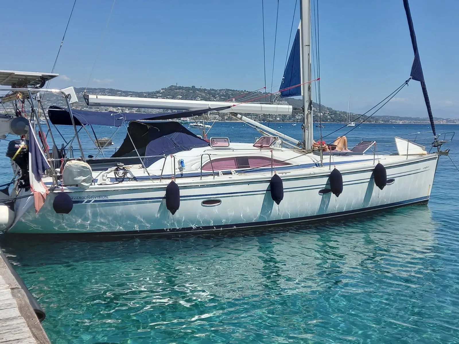 Bavaria Vision 44 — Voilier blanc amarré, vu de profil, dans une baie ensoleillée.