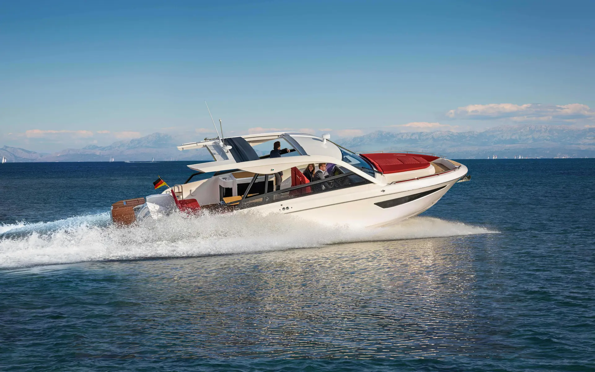Bavaria Vida 33 Coupe — Bateau à moteur blanc naviguant rapidement devant un littoral montagneux