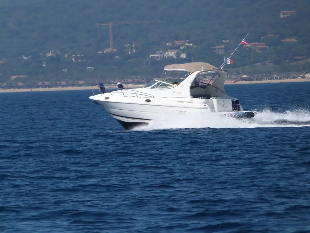 Cruisers Yachts 3075 Express — Bateau à moteur blanc naviguant au large, photographié de trois quarts.