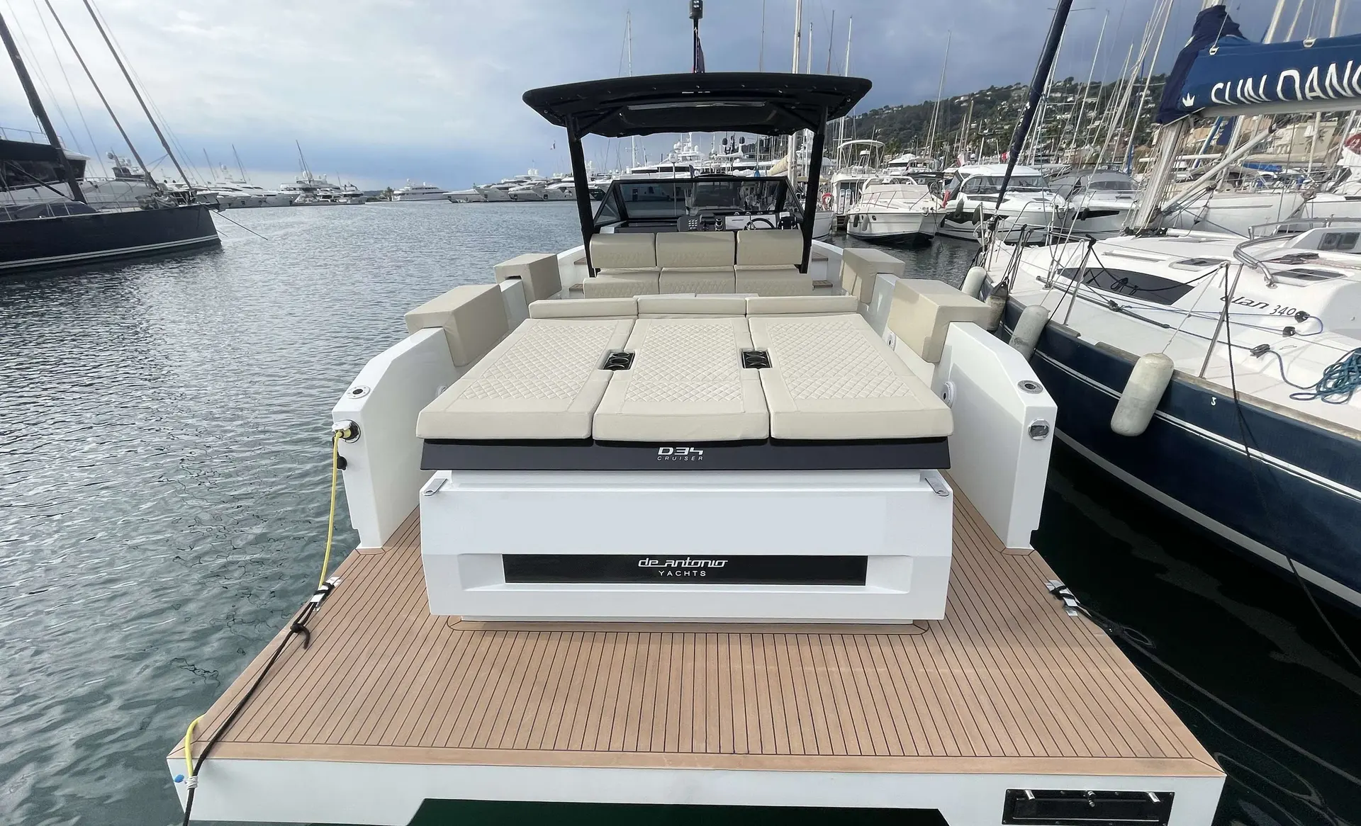 De Antonio Yachts D34 Cruiser — Vue arrière du pont et de l'espace extérieur d'un bateau amarré dans un port.