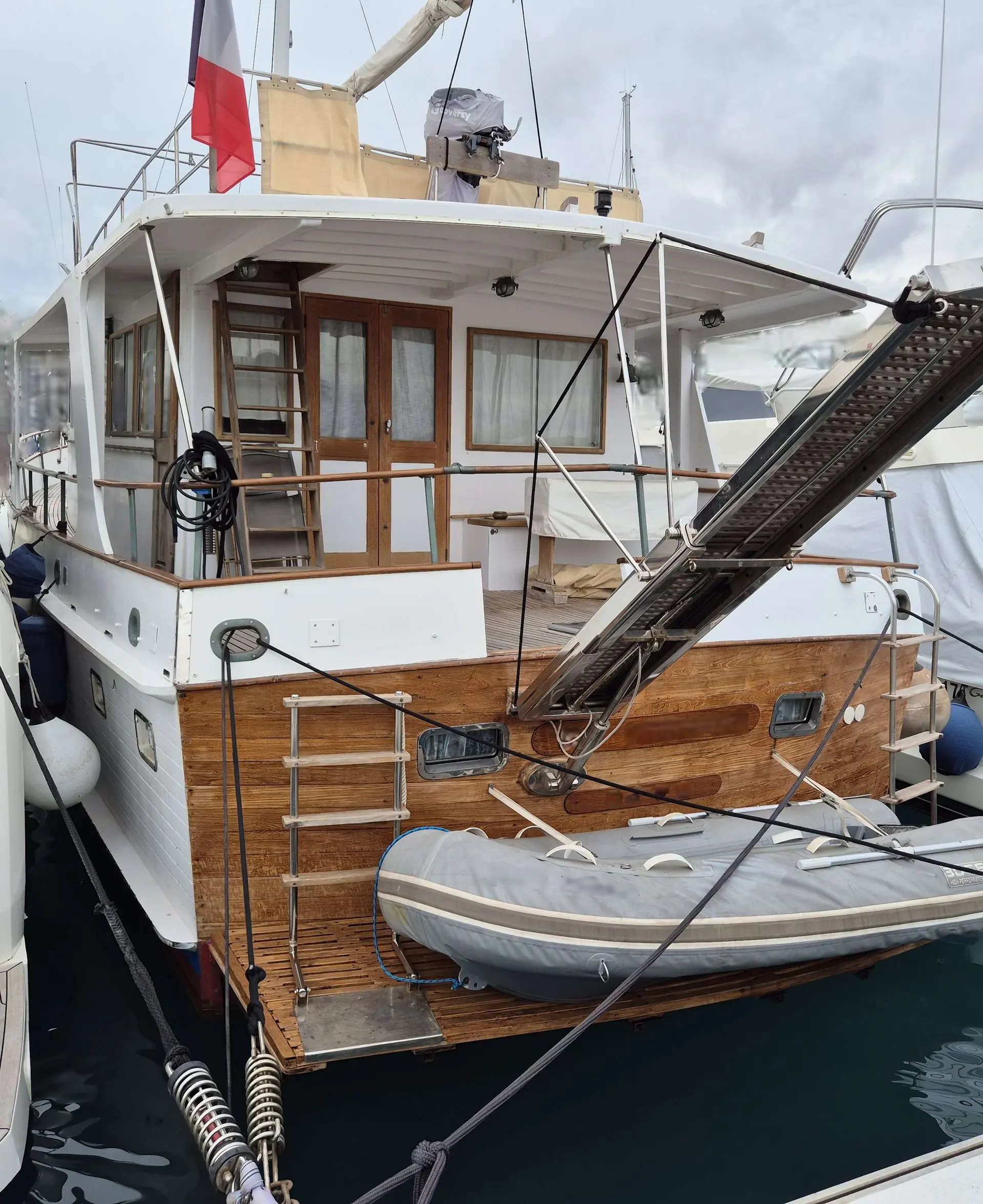 Grand Banks 50 — Vue arrière d’un bateau amarré, avec annexe, passerelle et cockpit visibles.