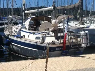 Hallberg Rassy 36 — Voilier amarré vu de trois-quarts arrière dans un port de plaisance.