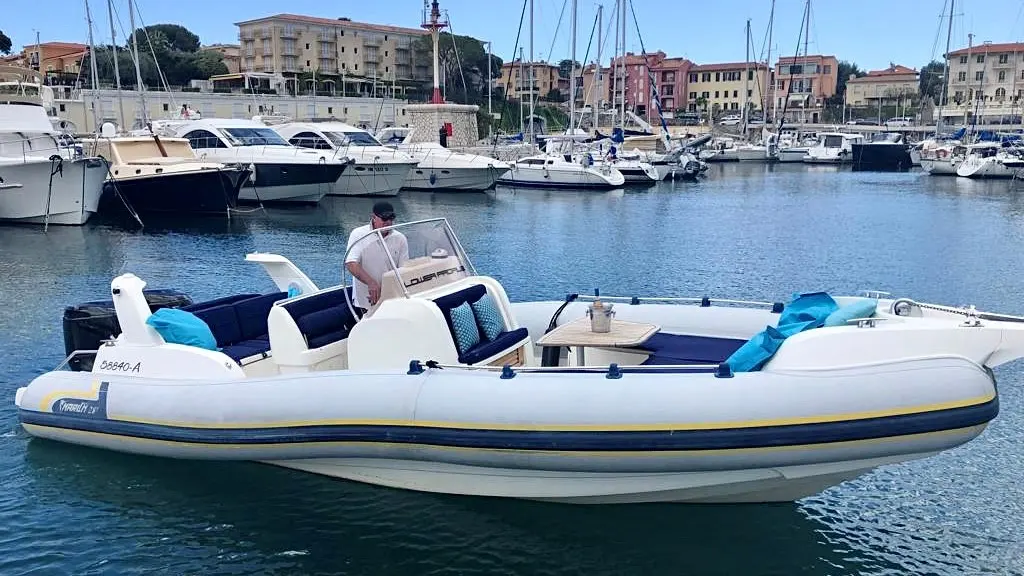 Marlin Boat 23 FB — Semi-rigide blanc photographié de profil dans un port, avec une personne à la console.