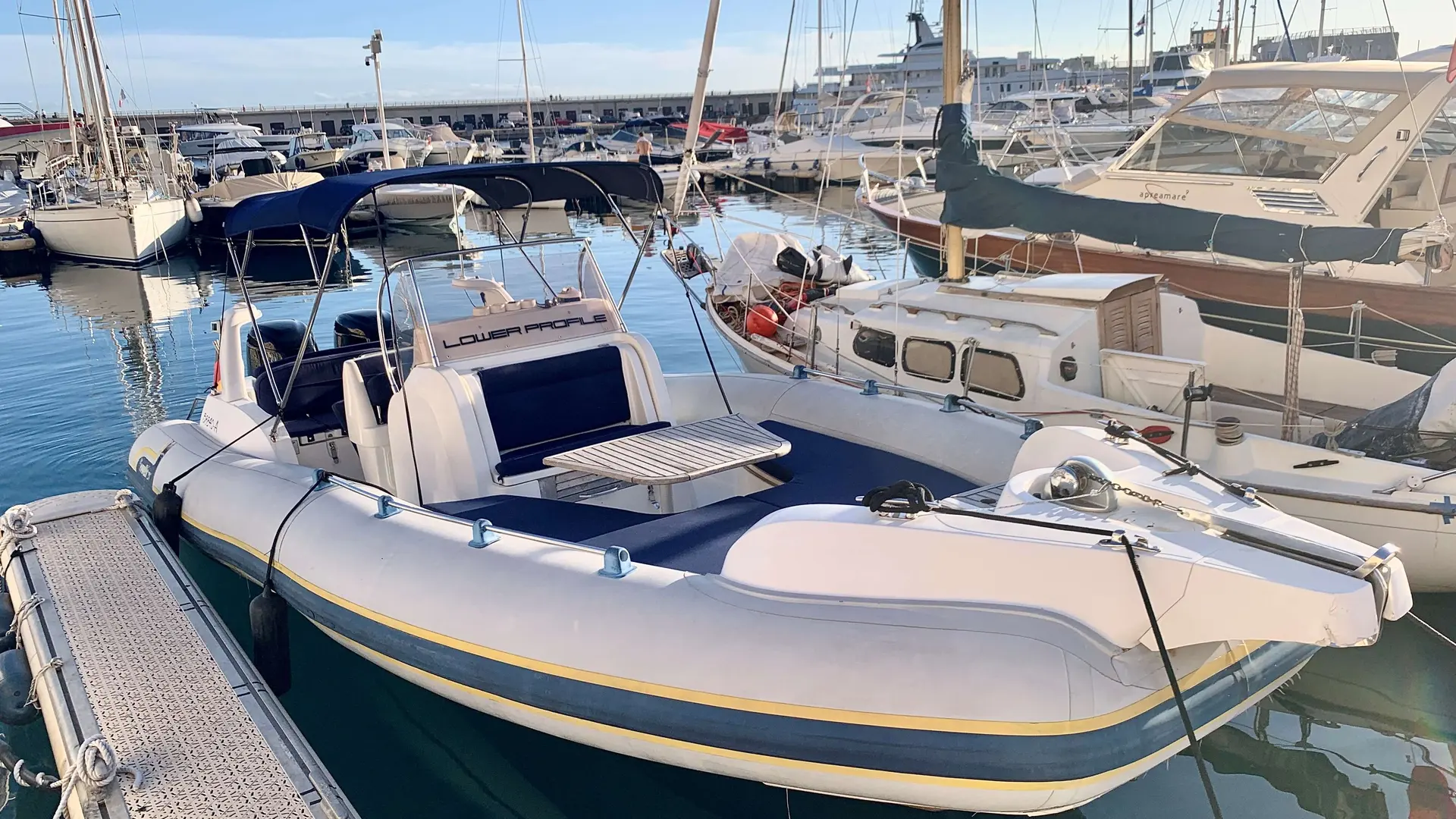 Marlin Boat 23 FB — Semi-rigide blanc et bleu amarré dans un port de plaisance.