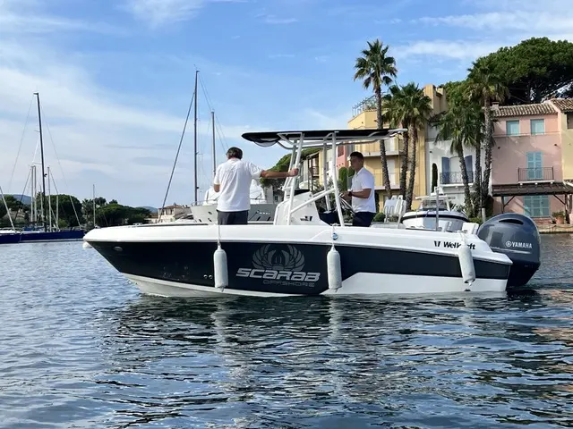 Wellcraft Fisherman 182 — Vue latérale d’un bateau blanc et bleu amarré, avec deux personnes à bord.