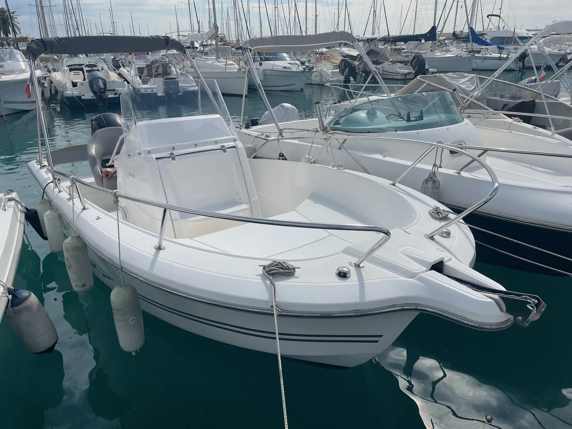 White Shark 206 — Bateau à moteur blanc amarré dans une marina, vu de trois quarts avant.