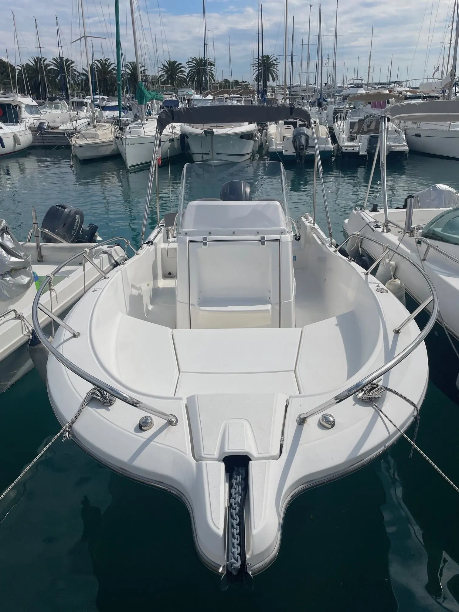 White Shark 206 — Bateau à moteur blanc amarré dans un port de plaisance, vu de l’avant.