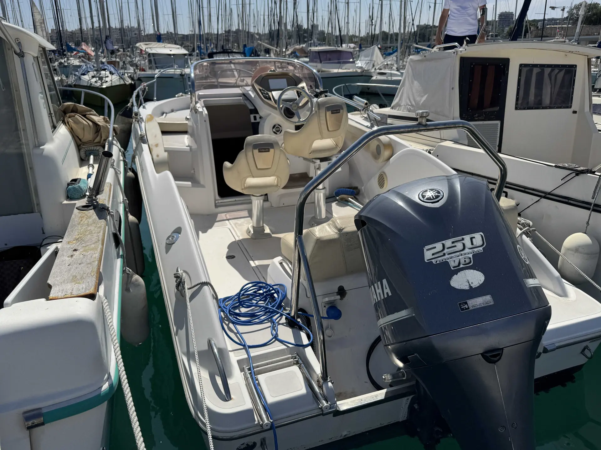 Sessa Marine Key Largo 24 — Vue arrière du cockpit et du moteur hors-bord dans une marina.