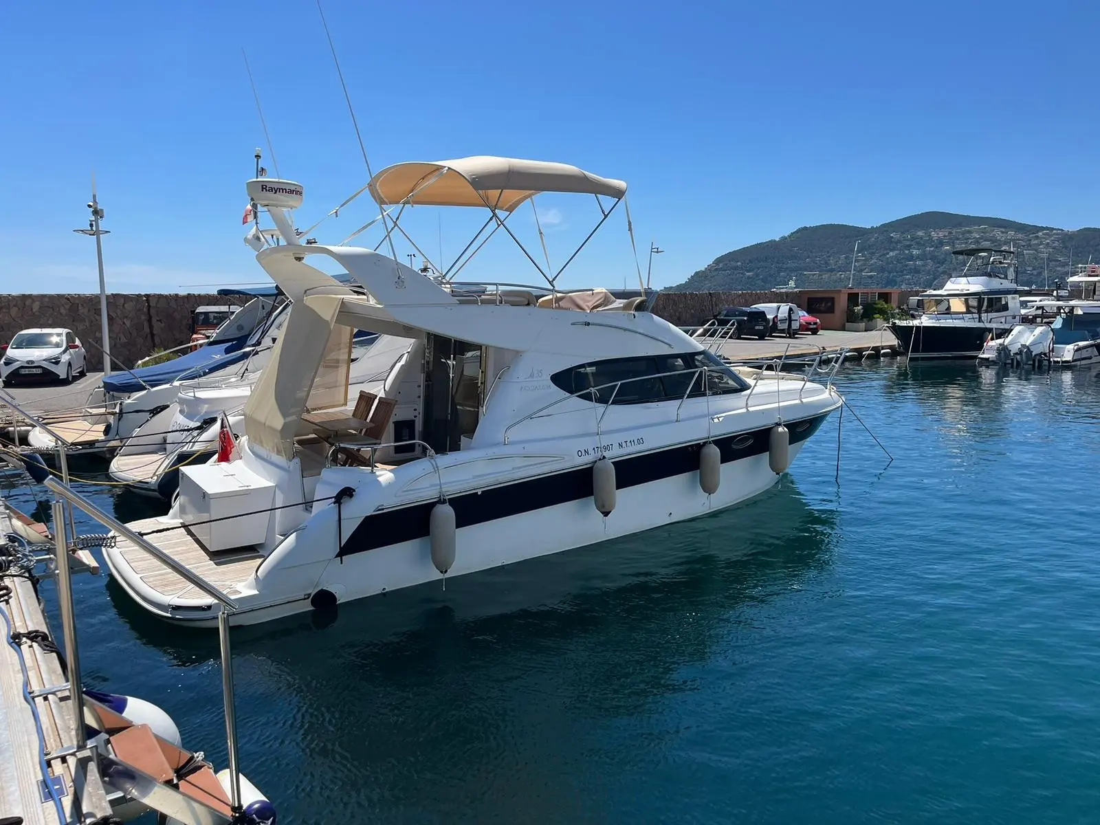 Aqualum 35 — Bateau à moteur blanc photographié de trois quarts dans une marina.