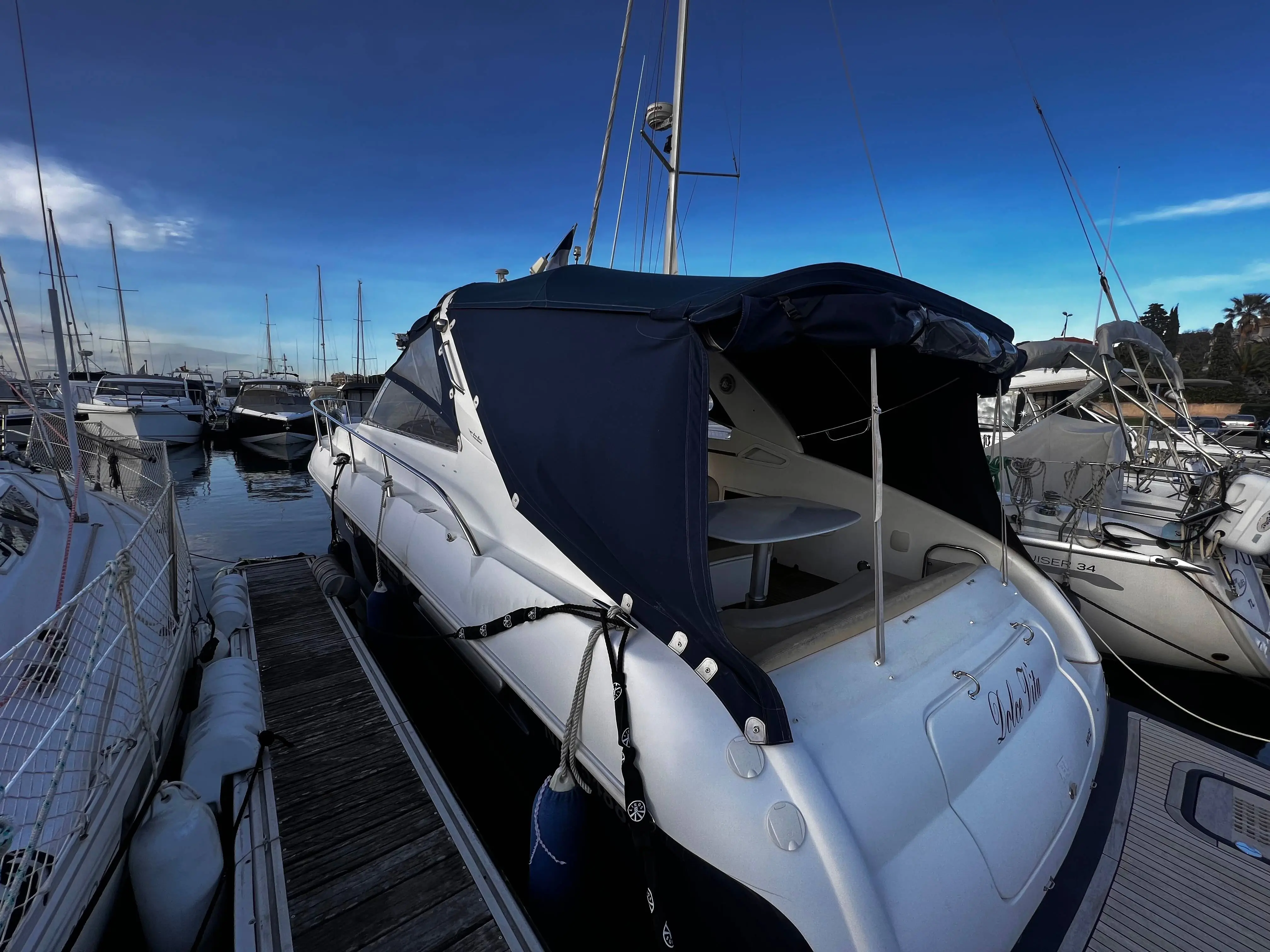Airon Marine 345 — Bateau à moteur vu de trois quarts arrière dans un port, avec taud de cockpit.