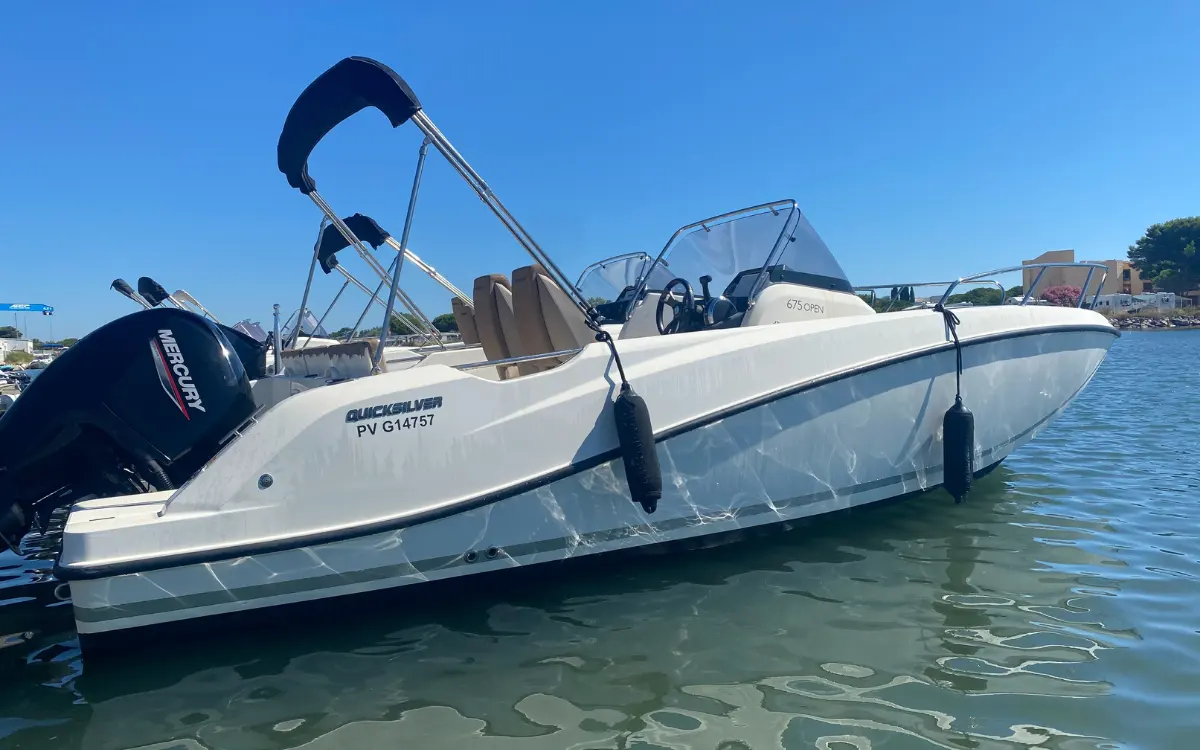 Quicksilver Activ 675 Open — Bateau à moteur blanc vu de trois quarts bâbord dans un port.
