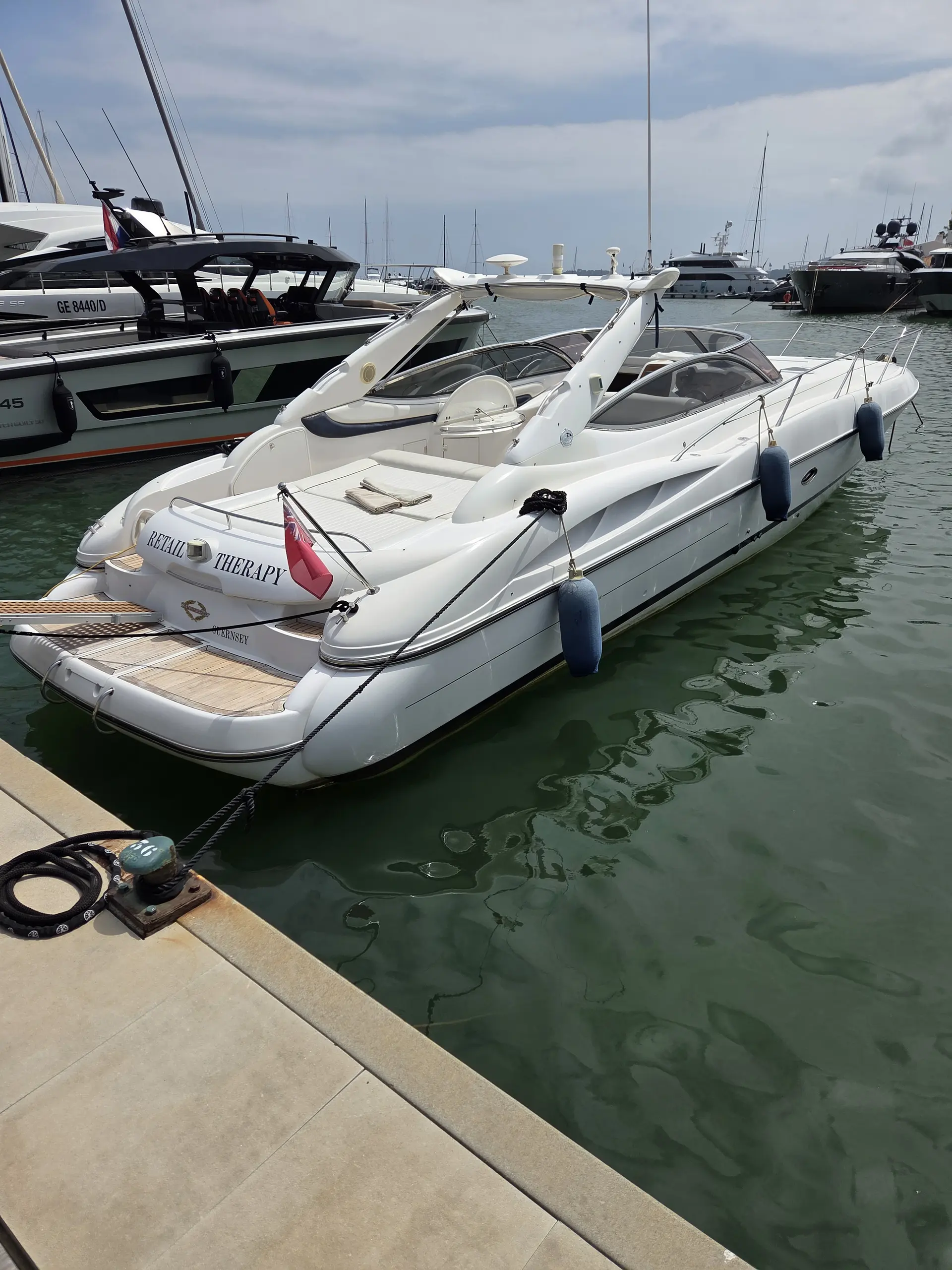 Sunseeker Superhawk 48 — Bateau à moteur blanc amarré dans un port, vu de trois quarts arrière.