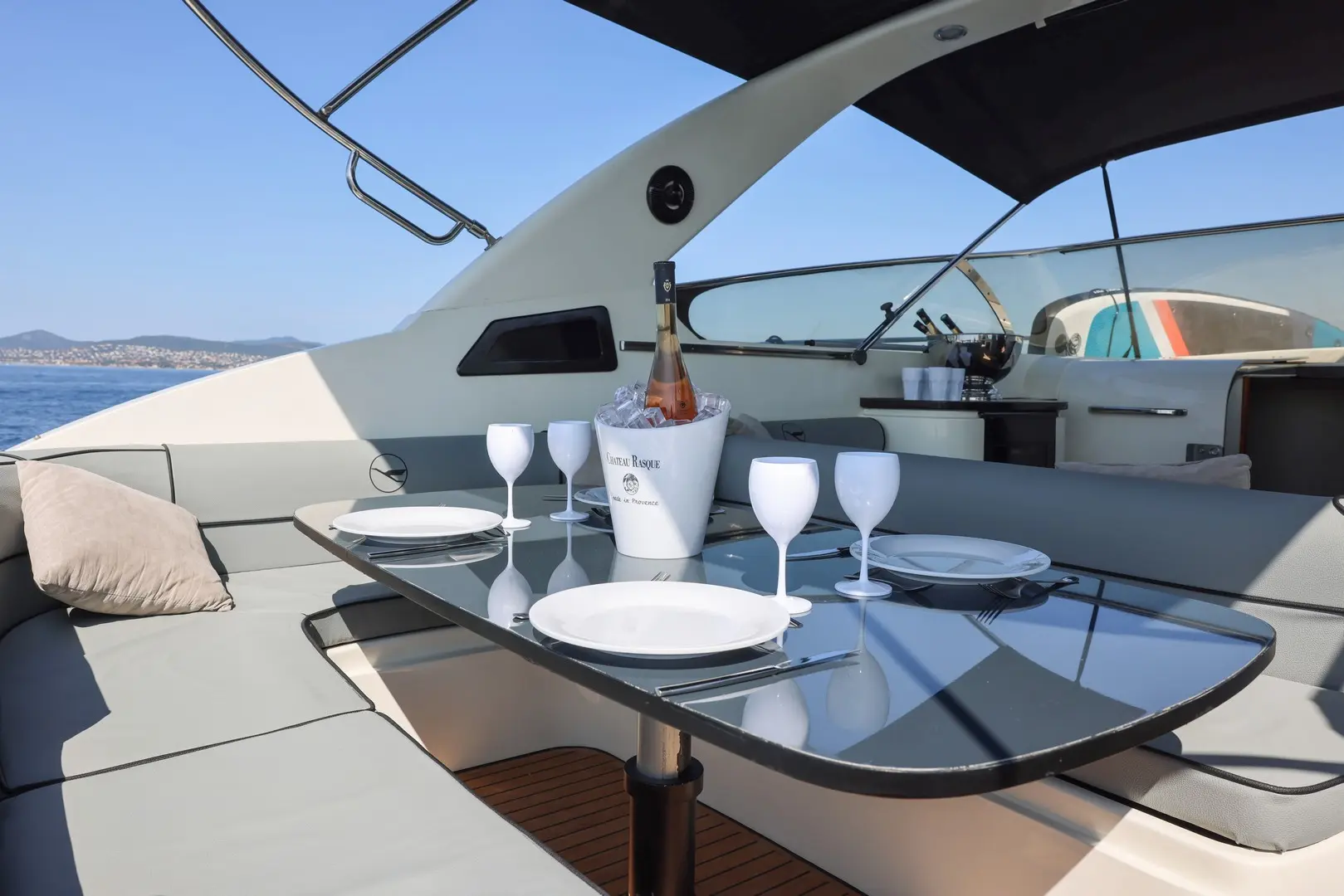 Airon Marine 388 — Cockpit extérieur avec table dressée, banquettes et vue sur la mer.