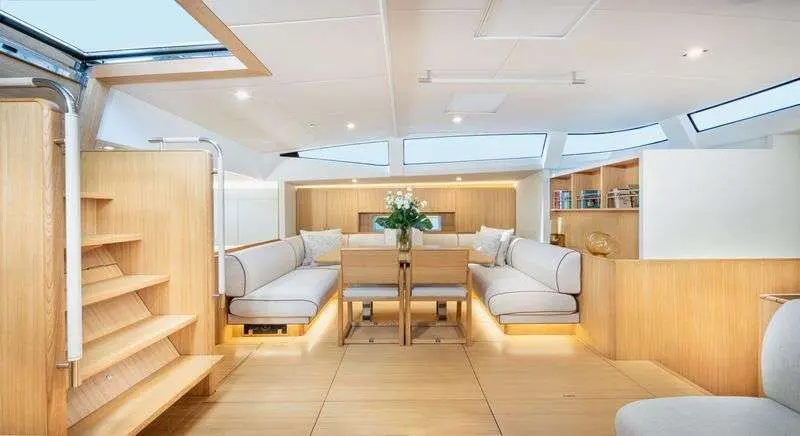 Solaris 74 RS — Salon intérieur lumineux avec banquettes, table, rangements et larges vitrages.