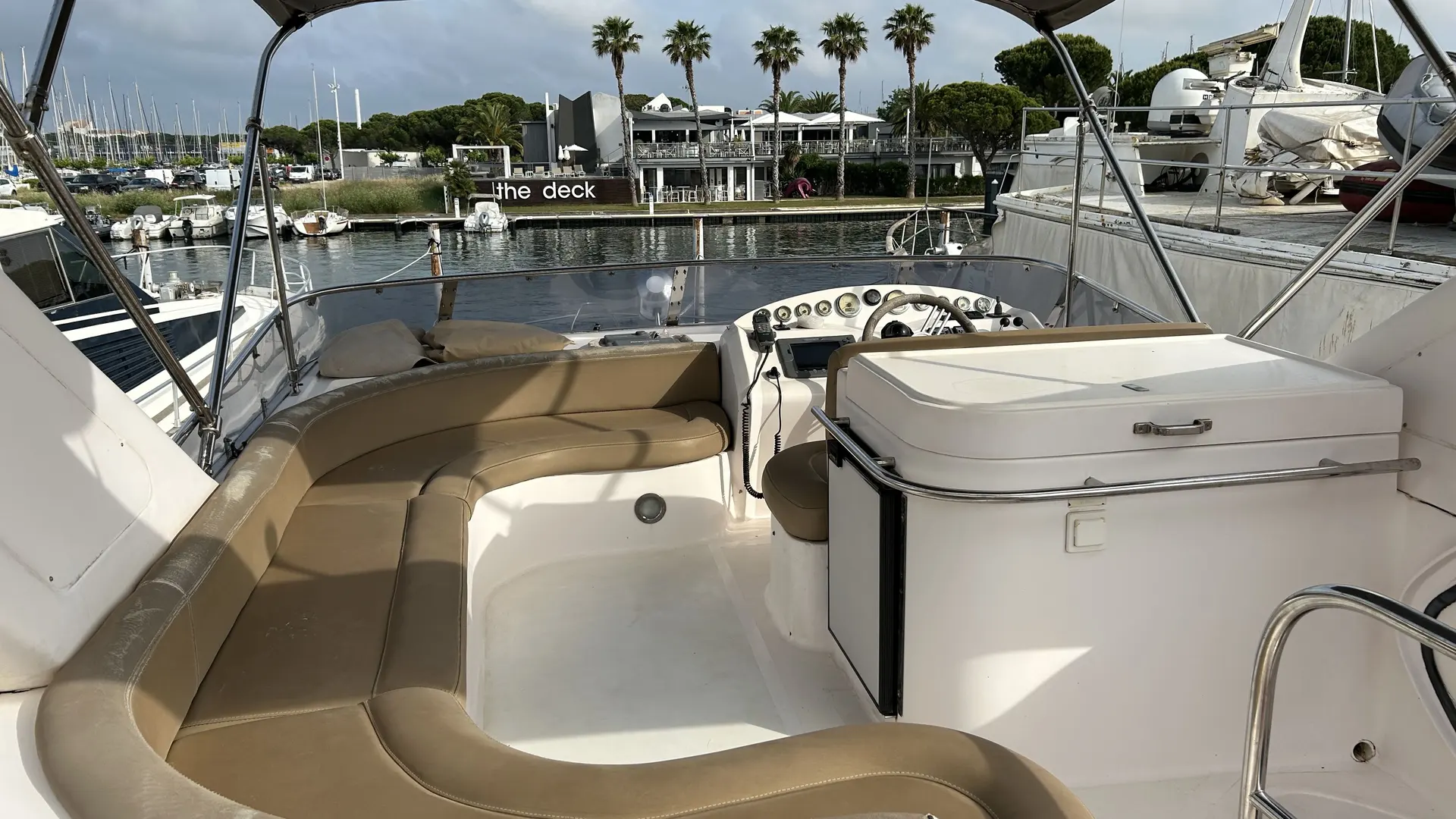 Majesty Yachts Majesty 50 — Vue du cockpit extérieur avec banquette, poste de pilotage et meuble de rangement.