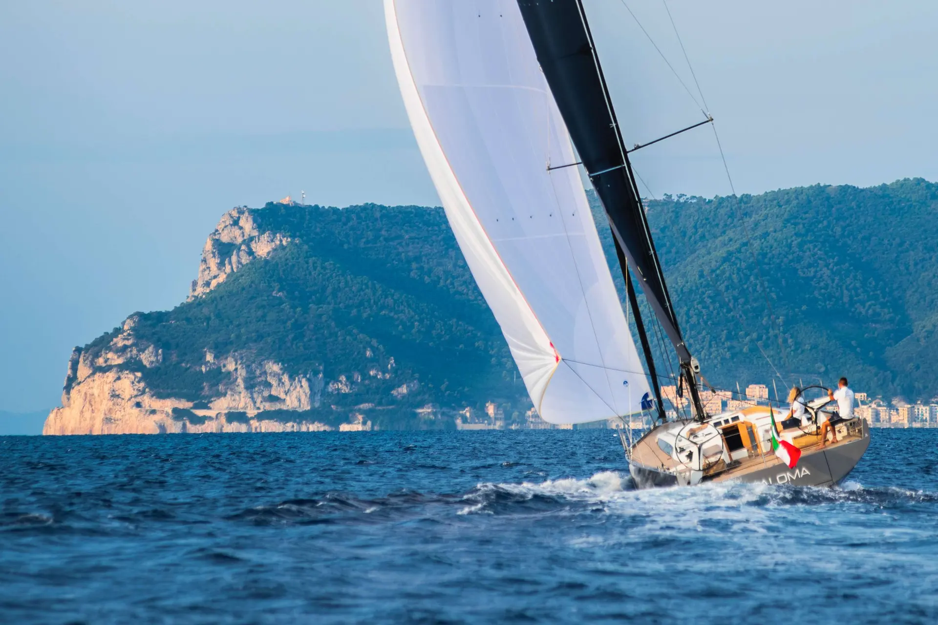 Solaris 40 ST — Voilier naviguant près d'une côte rocheuse, voiles déployées.