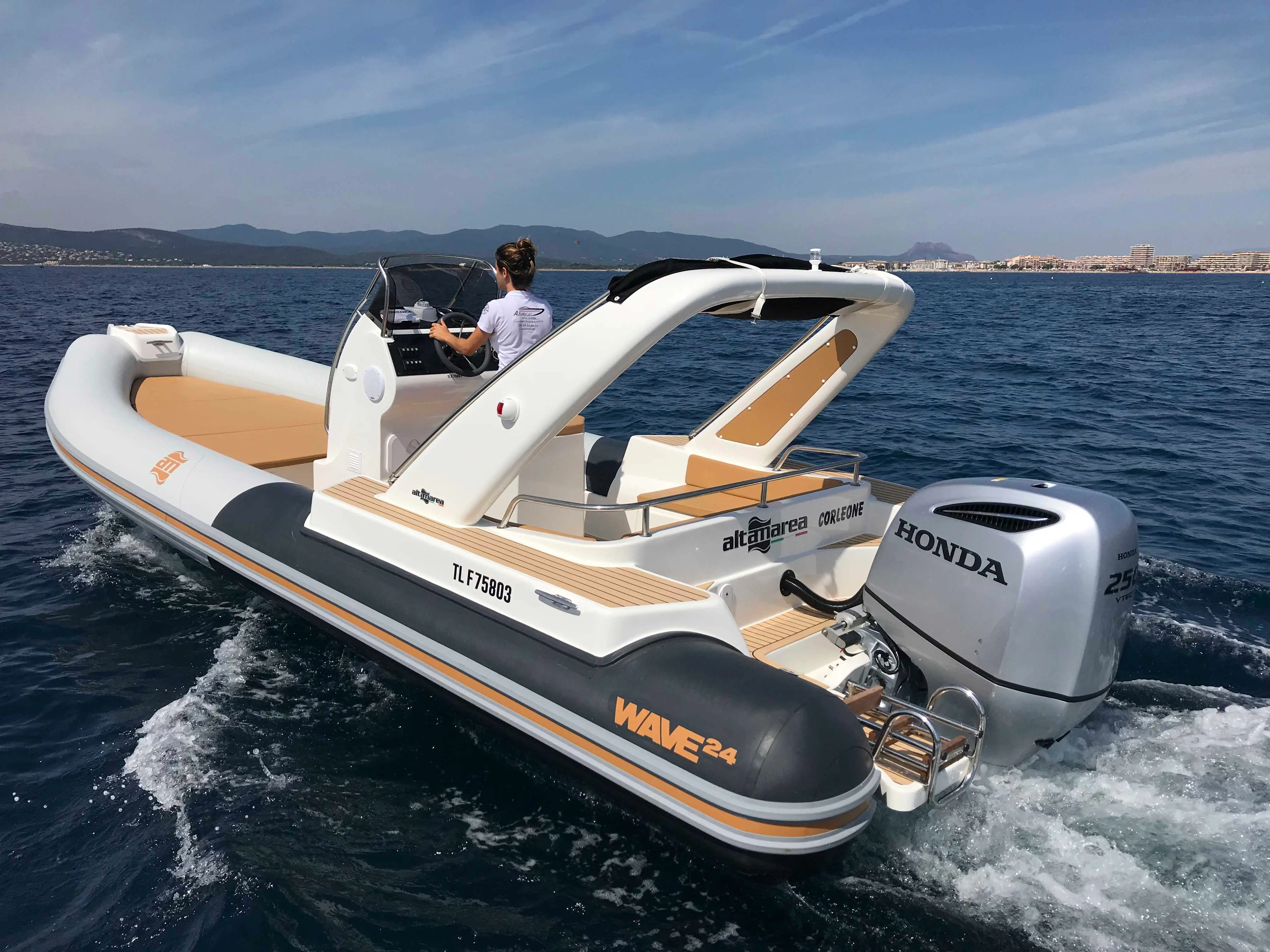 Altamarea Wave 24 — Bateau semi-rigide blanc et orange naviguant au large, vu de trois quarts arrière.