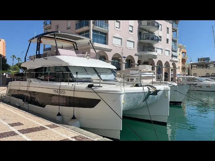 Fountaine Pajot My 40 — Catamaran à moteur blanc amarré dans un port, vu de trois quarts avant.