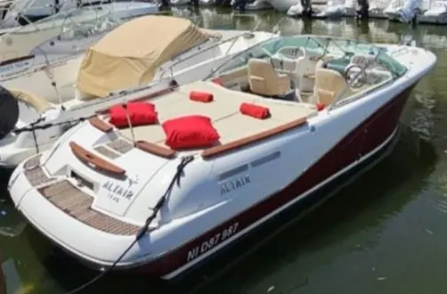 Jeanneau Runabout 755 — Vue en trois-quarts arrière d’un bateau blanc et rouge amarré dans un port.