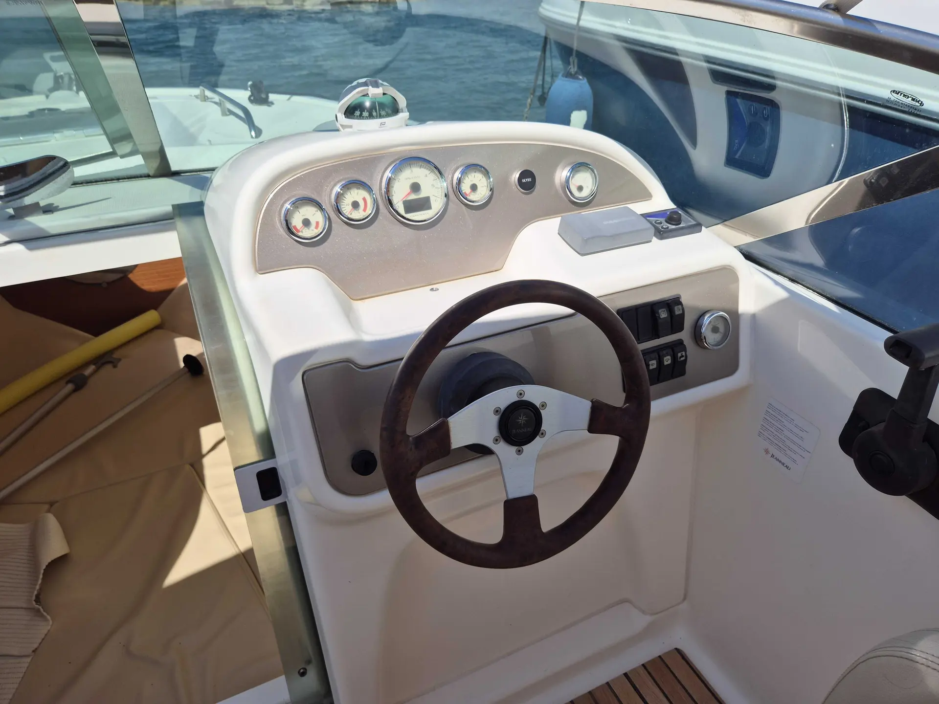 Jeanneau Runabout 755 — Poste de pilotage avec volant, instruments et commandes visibles.