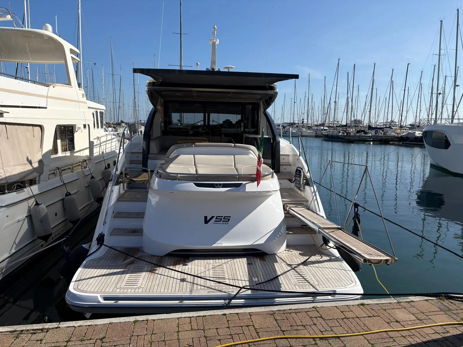 Princess V55 — Vue arrière d’un bateau à moteur amarré dans un port de plaisance.
