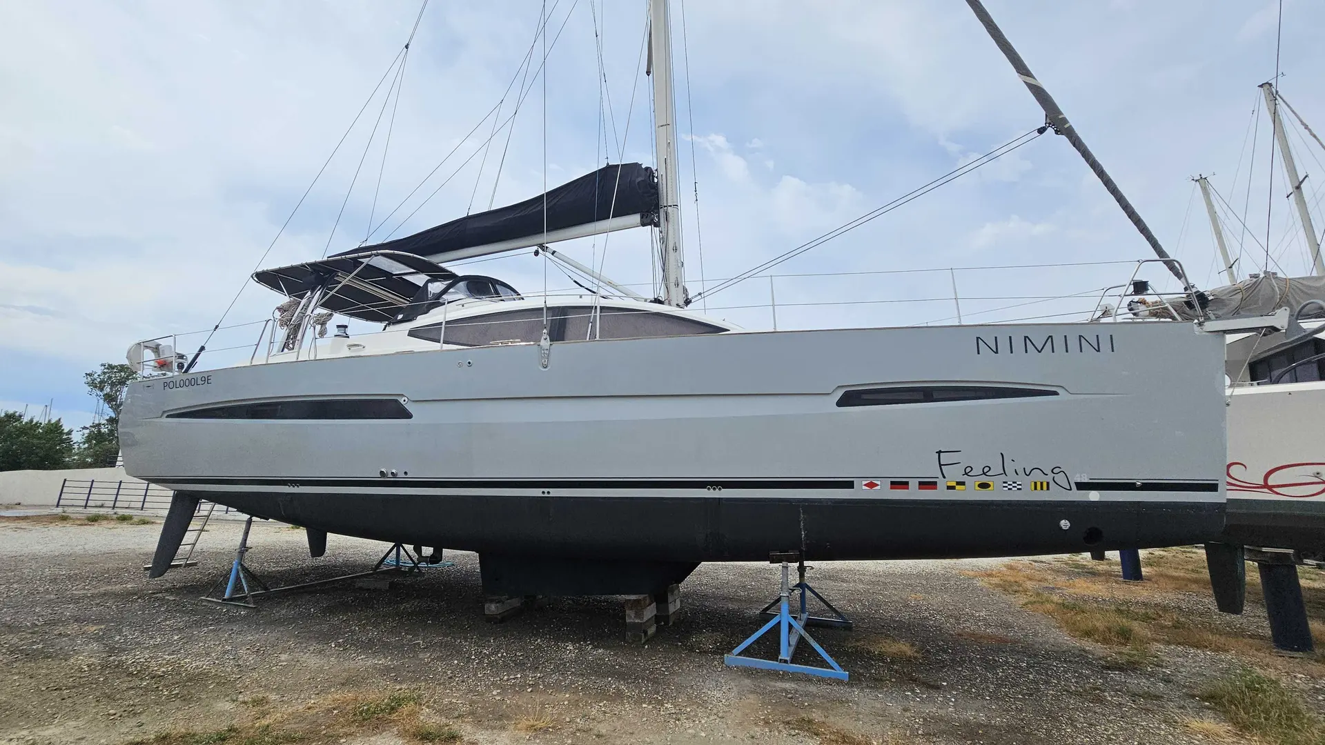 Alliaura Marine Feeling 48 — Voilier blanc vu de profil, posé à terre sur ber, avec ses voiles ferlées.
