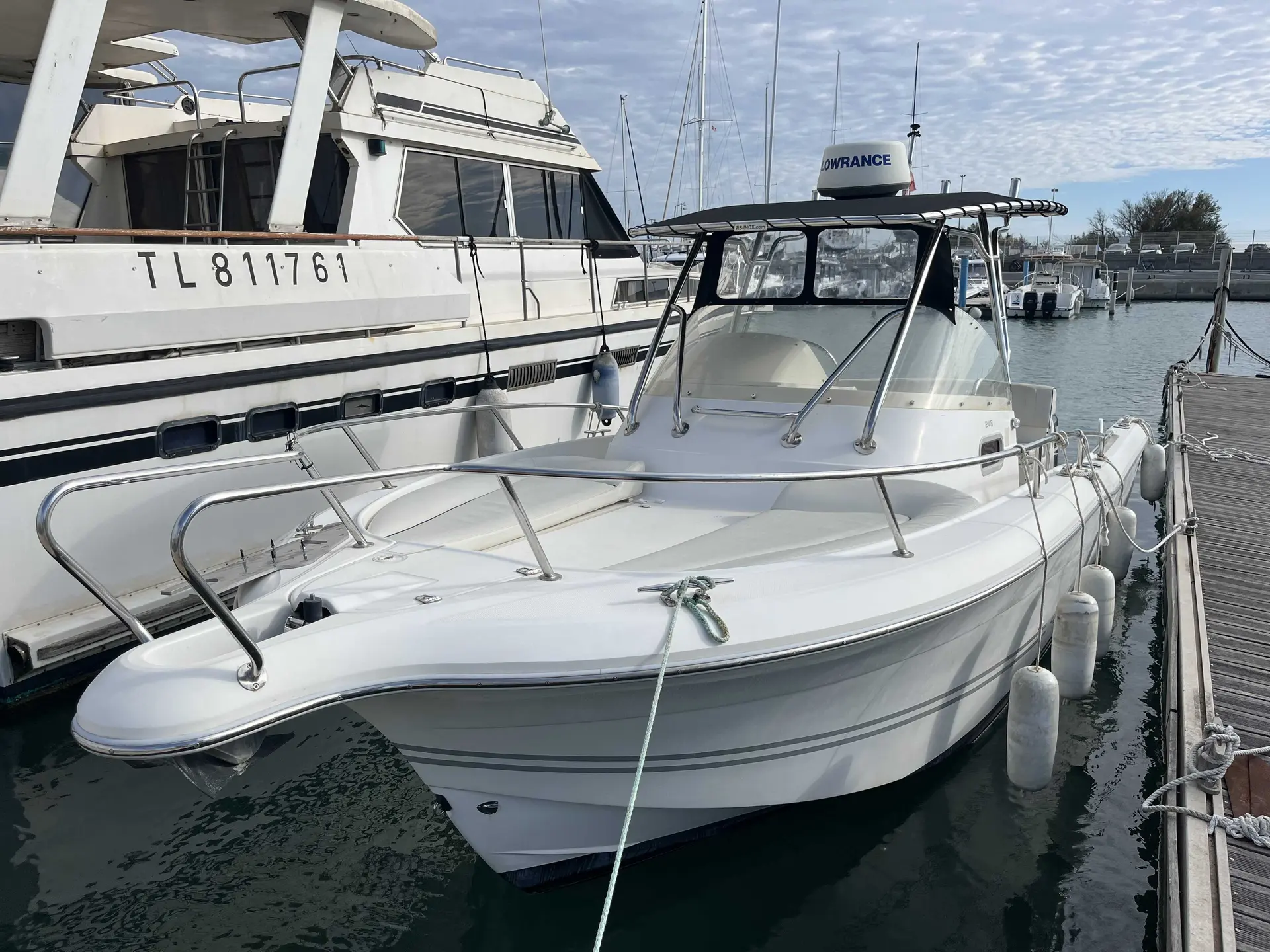 White Shark 248 — Bateau à moteur blanc amarré dans un port, vu de trois quarts avant.