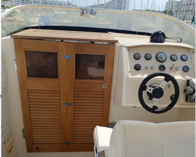 Rocca Guepard — Vue du poste de pilotage et d’un meuble en bois à bord du bateau.