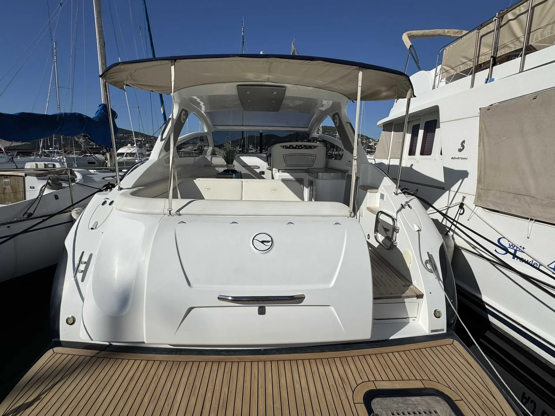 Airon Marine 4100 T-Top — Vue arrière d’un bateau à moteur blanc amarré dans une marina, taud installé.