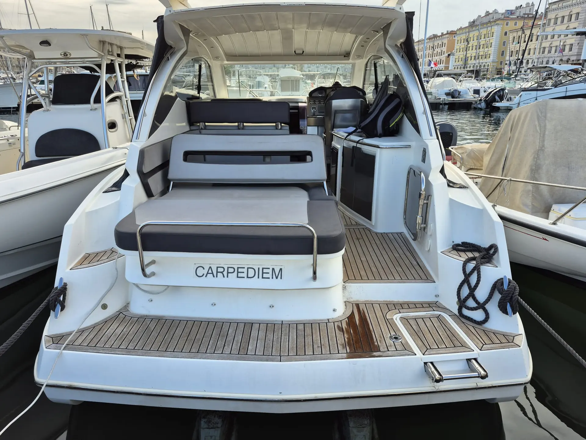 Galeon 325 HTO — Vue arrière du cockpit et de la plateforme arrière d’un bateau amarré.