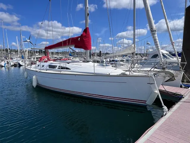 Jeanneau Sun Fast 37 — Voilier blanc amarré dans une marina, vu de trois quarts côté tribord.