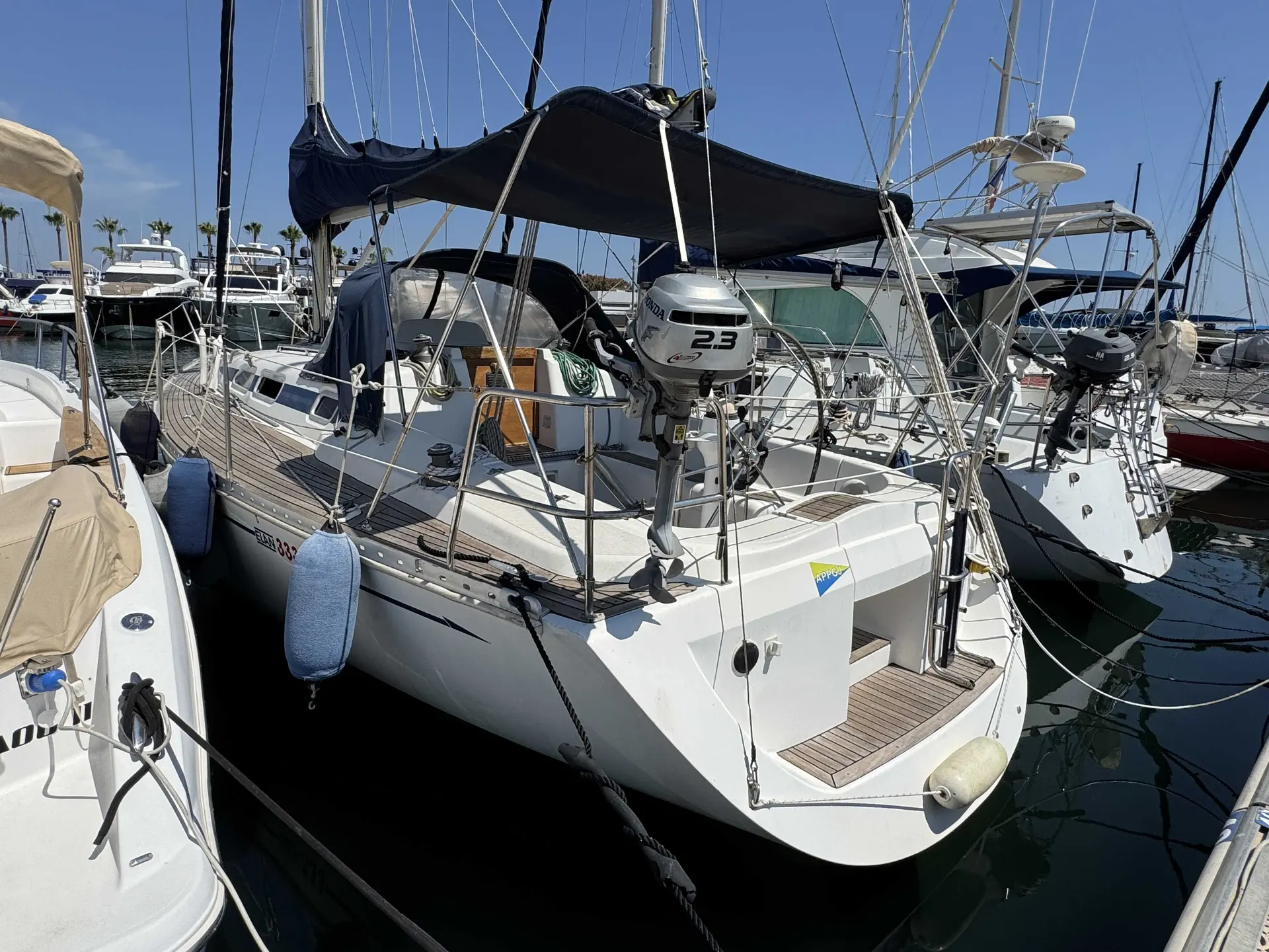 Elan 333 — Voilier blanc amarré, vu depuis l'arrière dans un port de plaisance.