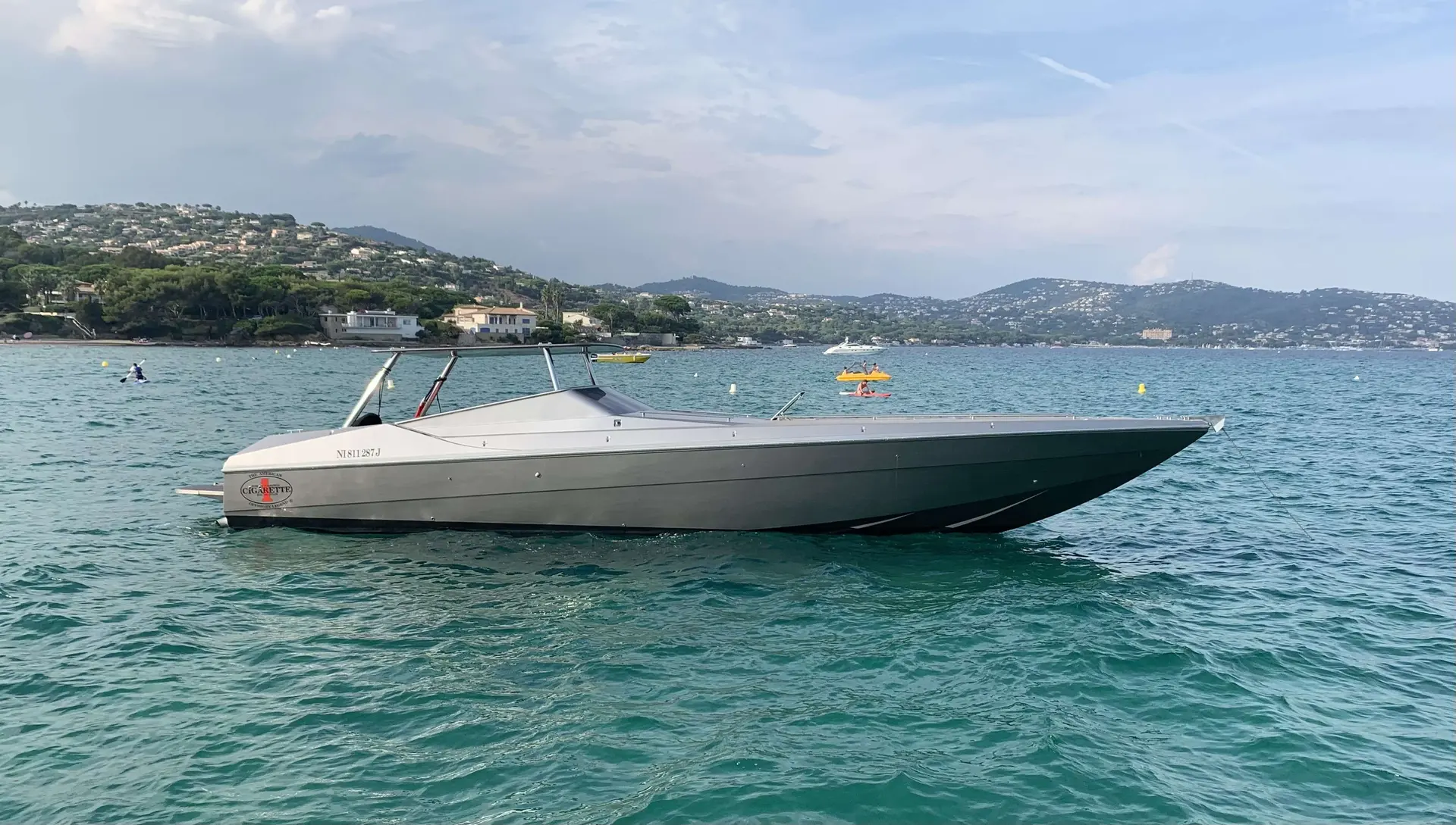 Benetti 45 — Bateau à moteur vu de profil sur une baie, avec des collines en arrière-plan.