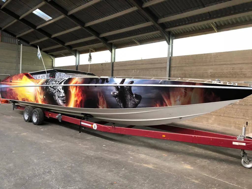 Cougar 38 Sport — Bateau à moteur décoré, photographié de profil sur sa remorque dans un hangar.