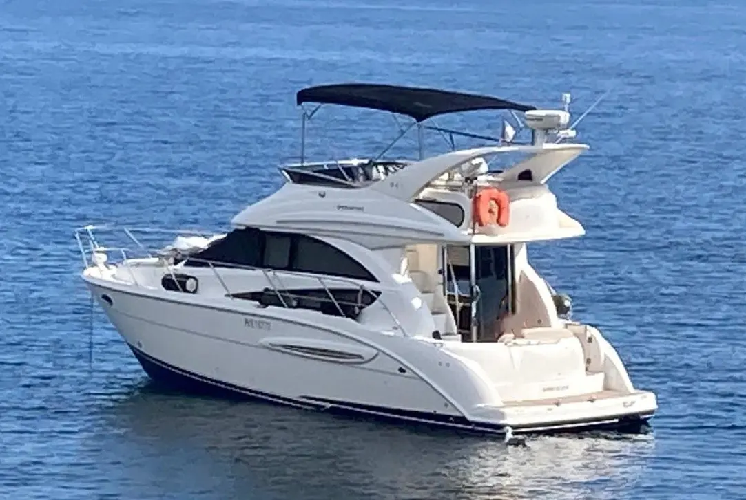 Meridian Yacht Sedan 341 — Bateau à moteur blanc vu de trois quarts arrière sur une mer bleue.